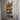 Handmade industrial pipe wine rack holding bottles on rustic wooden wall