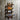 Industrial steampunk pipe wine rack holding four bottles on rustic wooden wall