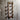 Industrial copper pipe wall shelving with steampunk style, mounted on rustic wooden wall.