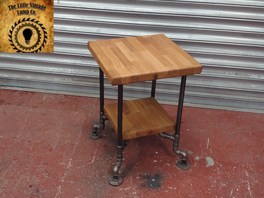 Industrial side table with solid wood shelves and metal pipe legs on a red floor