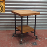 Industrial side table with wooden shelves and black metal pipe legs, steampunk furniture style