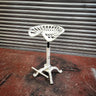 White steampunk industrial bar stool with tractor seat and cast iron base on red floor