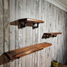 Industrial pipe wall shelves with dark wood on rustic wood panel wall