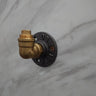 Industrial brass wall coat hook with flanged base on a marble surface