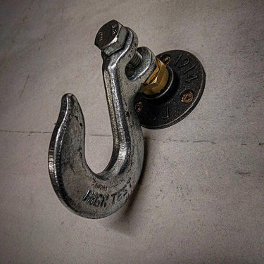 Industrial metal coat hook mounted on wall with vintage hardware fittings
