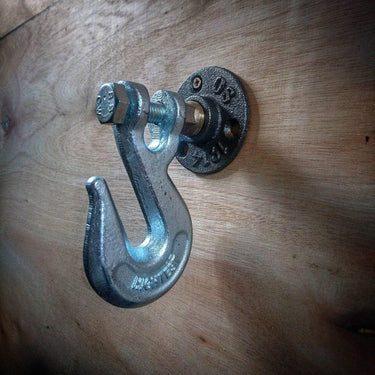 Industrial metal coat hook with pipe flange mount on wooden wall, steampunk style decor