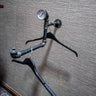 Wall-mounted industrial pipe clothes hanger rail with gauge and black hangers