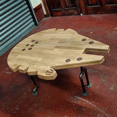Handmade Millennium Falcon shaped wooden coffee table with industrial pipe legs.