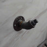 Retro industrial coat hook made from metal pipe, mounted on a marble wall