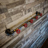Retro industrial coat rack with red valve hooks on rustic wood wall