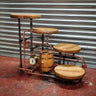 Rustic hardwood cake stand with steampunk industrial pipes, copper gauge, and barrel decor.