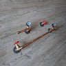 Handmade steampunk pipe toilet set with copper pipes, red valve handles, and pressure gauges