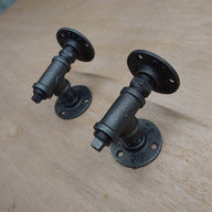 Pair of industrial steampunk pipe wall brackets by The Little Vintage Lamp Co on wood.
