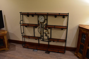 Industrial steampunk shelving unit with metal pipes, wood shelves, and vintage pressure gauges