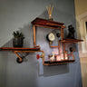 Industrial steampunk wall shelf with copper pipes, wood planks, pressure gauge, and decor