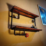 Steampunk industrial wall shelf with wooden planks, black iron pipes, gauges, and red valve