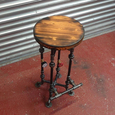 Steampunk industrial stool with wooden top and metal pipe legs, perfect for vintage decor