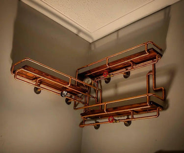 Steampunk shelving unit with copper pipes, wood shelves, and vintage gauges in corner wall.