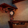 Steampunk industrial shelving unit with wood shelves, copper pipes, gauges, and valve on wall