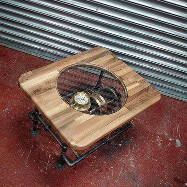 Handmade steampunk coffee table with wood top, glass inset, vintage gauge, and pipe legs