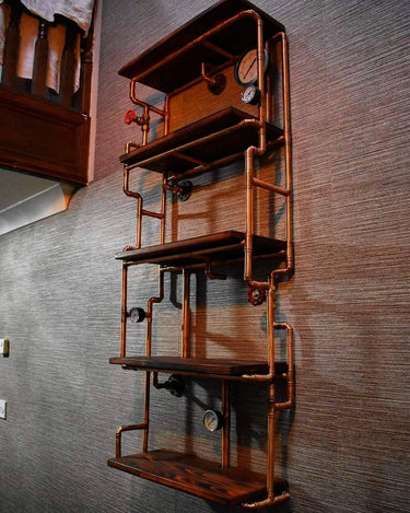 Steampunk industrial shelving unit with copper pipes, wood shelves, and gauge details on wall.