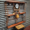 Steampunk shelving unit with copper pipes, wooden shelves, and industrial gauge decor