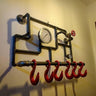Industrial steampunk coat rack made from metal pipes with red hooks and pressure gauges