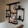 Steampunk industrial shelving unit with wood shelves, black metal pipes, gauges, and decor items on a wall