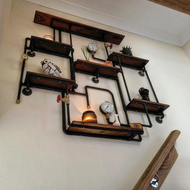 Industrial steampunk shelving unit with pipe frame, pressure gauges, and eclectic decor on wall.